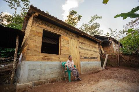 Woman sitting in front of a house.