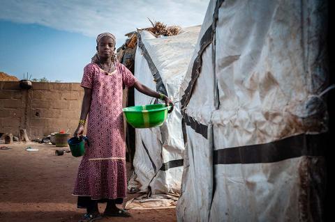 A child in front of a tent.