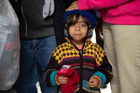 A child standing by people.