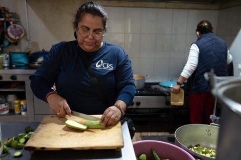 A woman cutting vegetables.