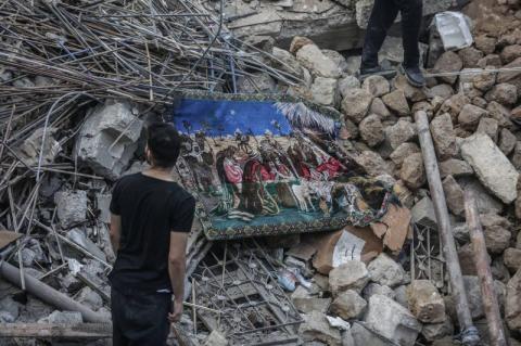 Hombre en frente de un edificio destruido