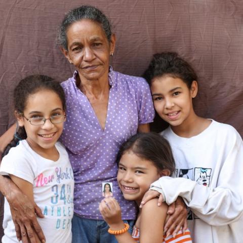 Abuela con vestido morado con 3 niños