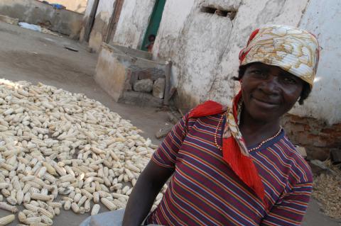A woman in front of collected crops.