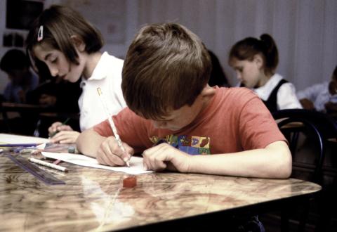 Children writing at their desks.