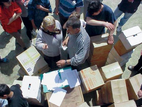 People standing around boxes.