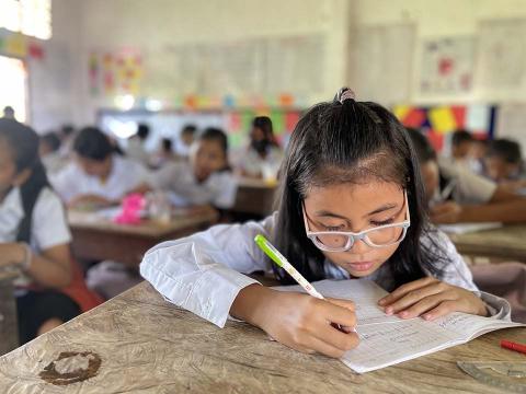 Children in a classroom, writing.