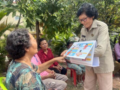 People looking at a learning booklet.