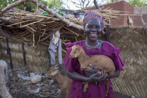 A woman holding a chicken.