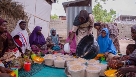 A group of people sitting around supplies.