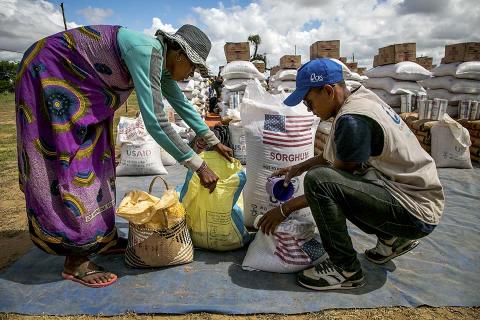 A man and a woman looking at supplies.