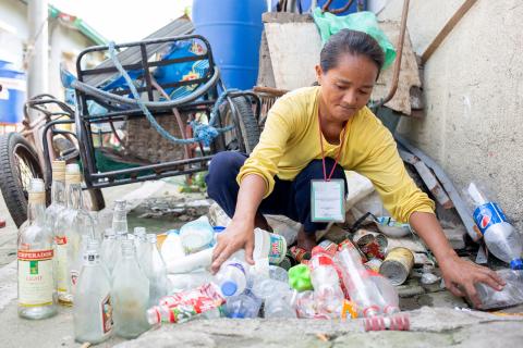 A woman gathering plastic bottles.