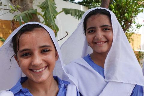 2 young girls in white head scarf.