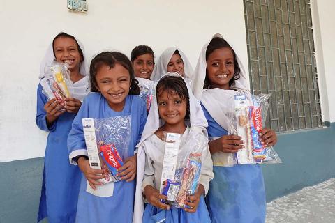 Young girls holding supplies.