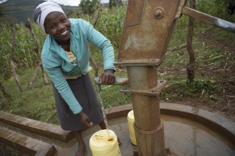 woman draws water in Uganda