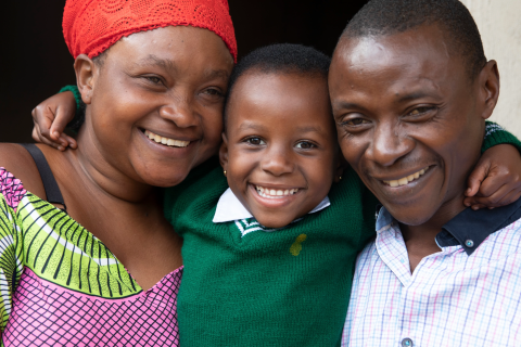 Una madre y un padre sonrientes abrazando a su hijo