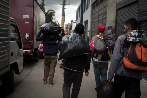 hombres caminando por la calle con bolsas