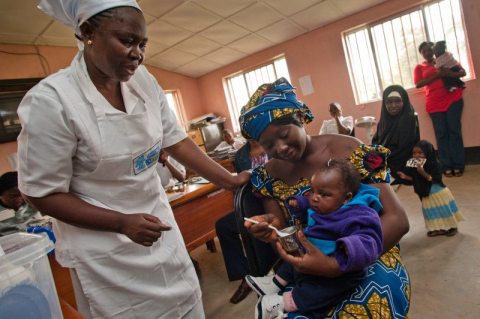 A nurse watching a woman and a child.