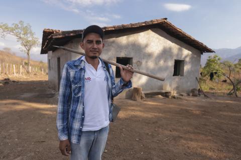 Man holding shovel in front of house