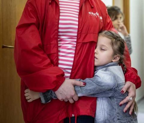 A child and a woman hugging.