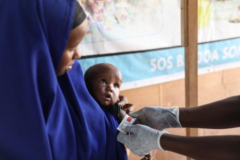 Woman holding a baby getting measured