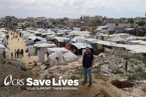 man standing in front of rubble and tents