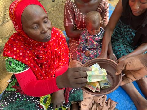 A woman giving her weekly contribution.
