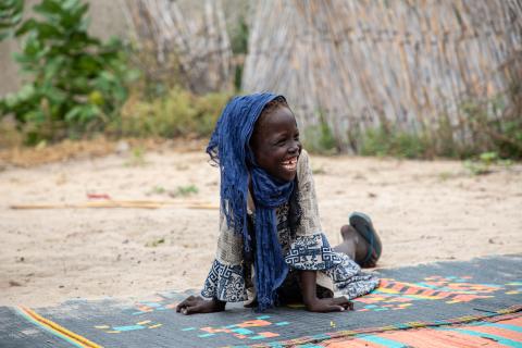 A young girl happily waiting for her mother.