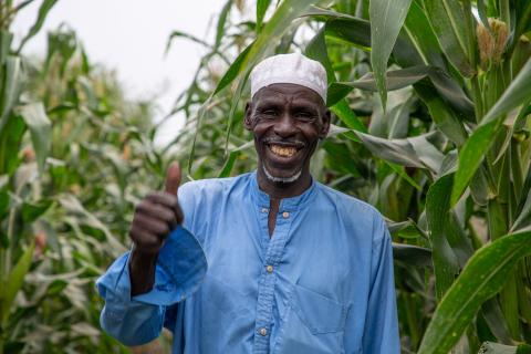 A man smiling and giving a thumbs up.
