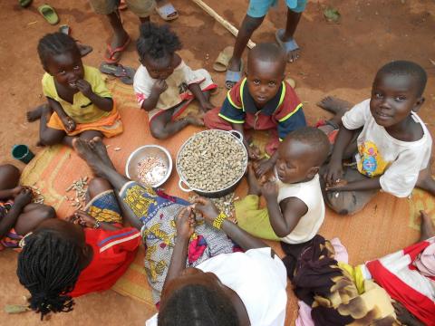 children sitting on ground, eating