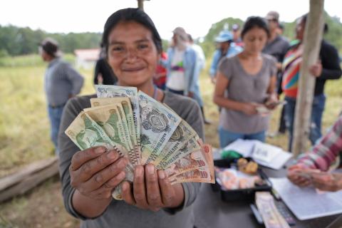 Una mujer sosteniendo un manojo de billetes.