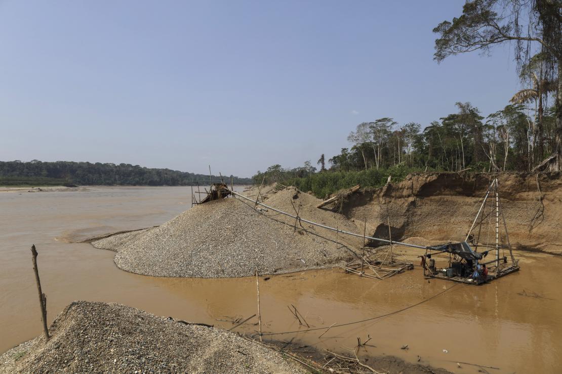 Using motors, sediment is dredged from the river and runs through a series of pipes and onto a platform with carpet where gold is trapped. Photo by Oscar Leiva/Silverlight for CRS