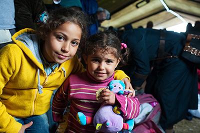 Syrian refugees Omama Basheer, left, and her sister, Rouya, enjoy a respite from their journey at Vasariste. Photo by Kira Horvath for CRS