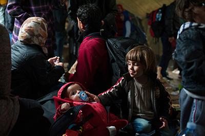 Syrian cousins wait inside a tent at Vasariste. Doctors and translators are working with CRS and Caritas to provide basic medical services and information about the border crossing. Photo by Kira Horvath for CRS