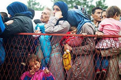 Refugees gather at a park near the Belgrade bus station waiting for transportation to the Hungary border. This year, thousands have fled countries in northern Africa and the Middle East seeking asylum in Europe. Photo by Kira Horvath for CRS