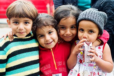 A group of Syrian children pose for a photo at a park near the Belgrade bus station. Photo by Kira Horvath for CRS
