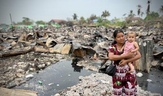 woman and baby with earthquake destruction around them