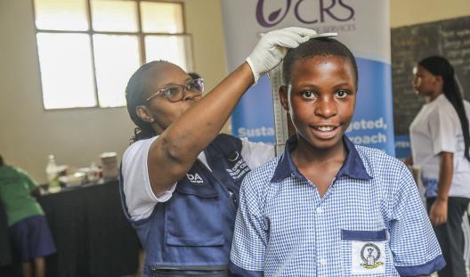 student getting height measured by health provider