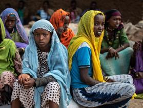 Group of women from Ethiopia sit in a circle looking at the camera