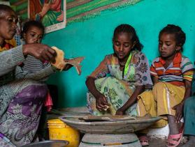 Woman and children from Ethiopia share dinner