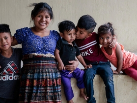 A mother and her four children hugging each other for a group photo  