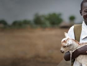 boy facing camera holds goat