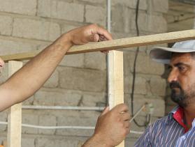 Local volunteers, most of them from the displaced community in northern Iraq, are trained by CRS’ building engineers on basic construction and installing doors and windows in buildings that have become temporary shelters. Photo by Kim Pozniak/CRS