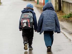 two refugee children walking away from camera