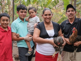 A family holding chickens 