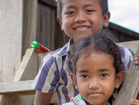 two children smiling facing camera in Cambodia
