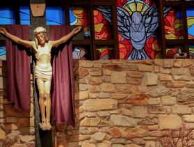 Crucifix in front of stained glass window in a church