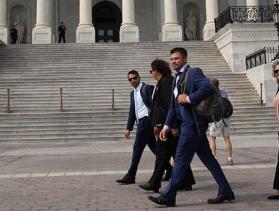 Group of people walks in front of the U.S. Capitol