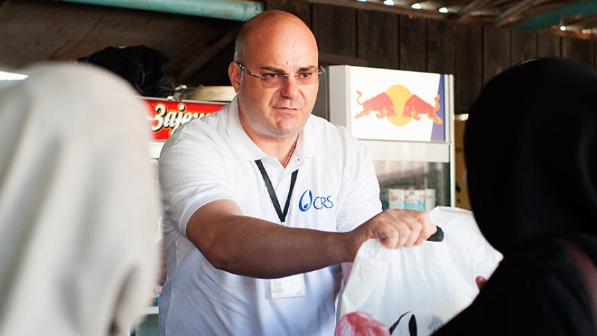 A man handing bags to people.